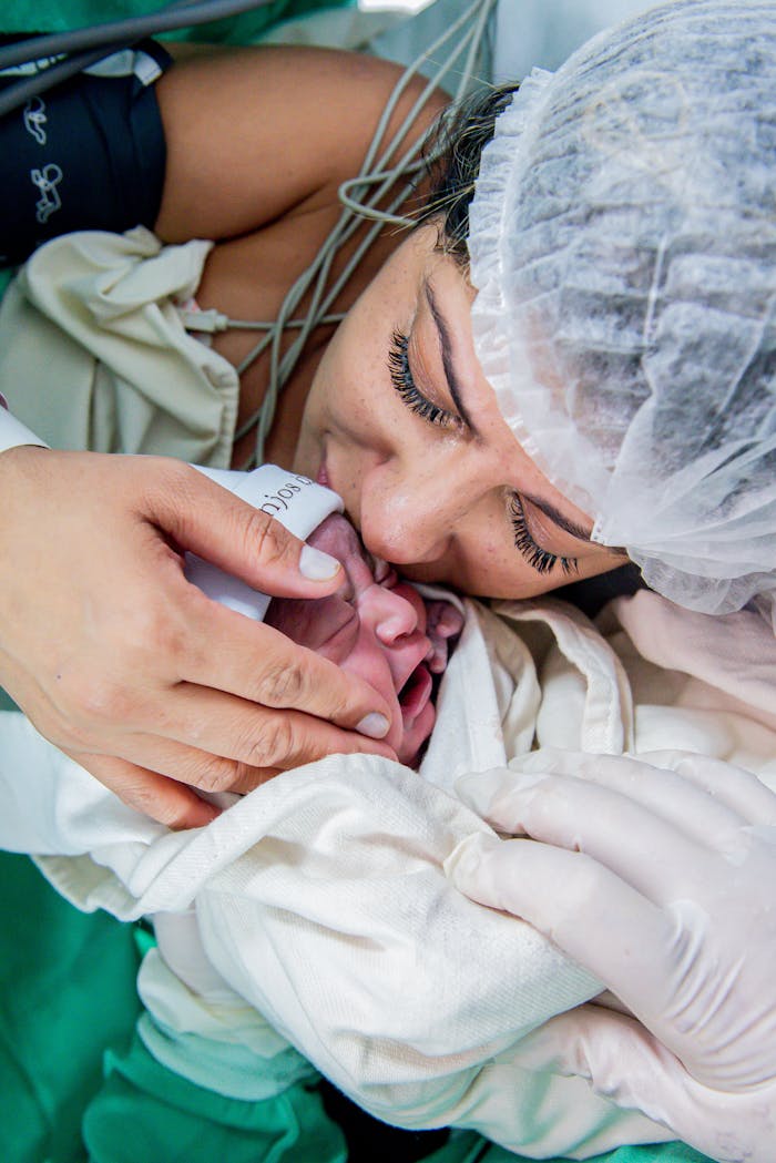 Home A mother lovingly embraces her newborn baby in a hospital setting, capturing a touching moment.